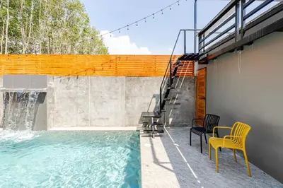 a swimming pool with two chairs and a table at Cactus Villa 2024, Krabi in Klong Muang Beach