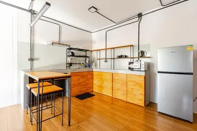 a kitchen with wooden cabinets and a refrigerator at Cactus Villa 2024, Krabi in Klong Muang Beach
