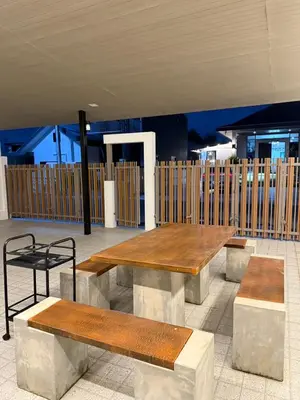 a group of benches and tables in a building at Luxsabai home in Ban Phlu Yai