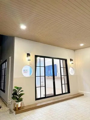 a room with a large window and a potted plant at Luxsabai home in Ban Phlu Yai