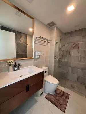 a bathroom with a toilet and a sink and a mirror at 2BR 4Beds Luxury Condo Pool & Fitness in Phuket Town