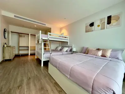 a bedroom with a large bed and bunk beds at 2BR 4Beds Luxury Condo Pool & Fitness in Phuket Town