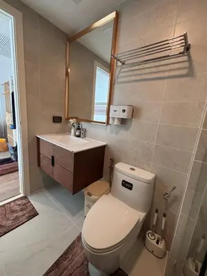 a bathroom with a toilet and a sink and a mirror at 2BR 4Beds Luxury Condo Pool & Fitness in Phuket Town