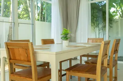 a white table with wooden chairs and a plant on it at V129 Walking To Award winning Naiharn Beach 4BR in Rawai Beach