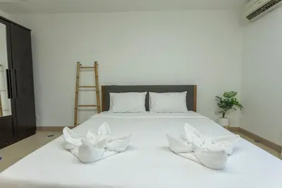a white bed with two white flowers on it at V129 Walking To Award winning Naiharn Beach 4BR in Rawai Beach