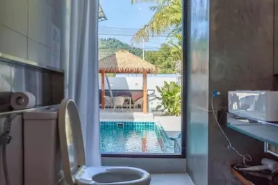a bathroom with a toilet and a swimming pool at V68 Paradise Found 2BR Villa Bliss in rawai in Kata Beach