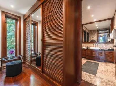 a bathroom with wood paneled walls and a large mirror at Baan View Talay - Sea View Zenith Villa By Elite Havens in Surin Beach