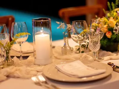 a table with a candle and plates and glasses at Baan View Talay - Sea View Zenith Villa By Elite Havens in Surin Beach