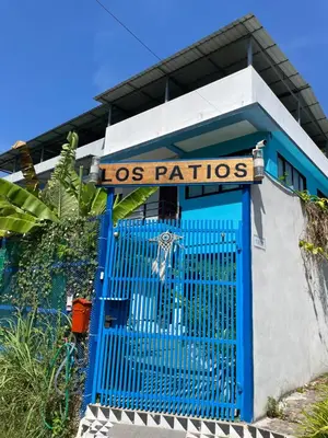 a blue gate in front of a los patios sign at Los Patios Hostel Phuket in Mai Khao Beach