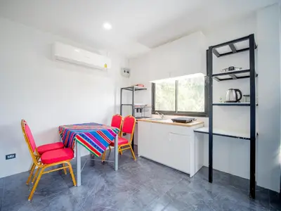 a kitchen with a table and two chairs and a counter at Los Patios Hostel Phuket in Mai Khao Beach