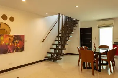 a dining room with a table and a spiral staircase at V69 15min Convenient to Patong Building Gym in Kamala Beach