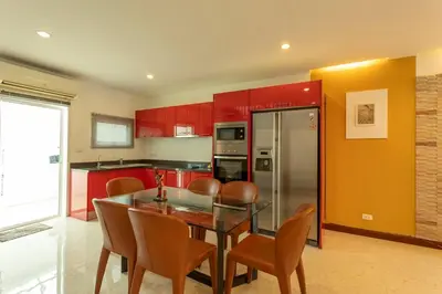 a kitchen with red cabinets and a glass table and chairs at V69 15min Convenient to Patong Building Gym in Kamala Beach