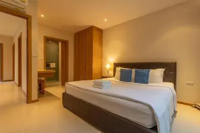 a bedroom with a large bed and a bathroom at V91 Where The Rich People Go Trichada Resort in Thalang