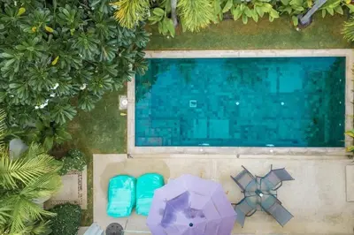 an overhead view of a swimming pool with a purple umbrella at V91 Where The Rich People Go Trichada Resort in Thalang