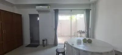 a white room with a table and a sliding glass door at Cosy Home in Koh Kaew in Ban Bang Khu
