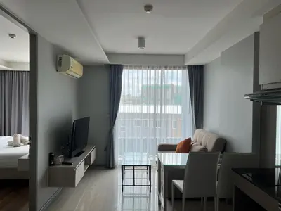 a living room with a couch and a table with a television at Condo Surin-Bangtao Beach in Surin Beach