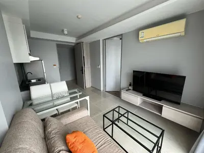 a living room with a couch and a flat screen tv at Condo Surin-Bangtao Beach in Surin Beach