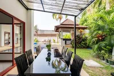 a dining room table and chairs in a backyard at Surin villa by Pattara in Surin Beach