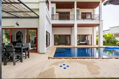 a house with a swimming pool in front of a house at Surin villa by Pattara in Surin Beach