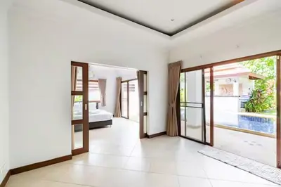 an empty room with doors to a bedroom and a pool at Surin villa by Pattara in Surin Beach