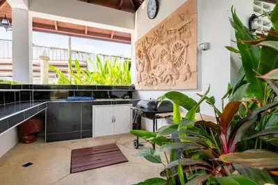 a room with a desk with a chair and plants at Surin villa by Pattara in Surin Beach