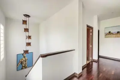 a white room with a staircase with a statue on the wall at Surin villa by Pattara in Surin Beach