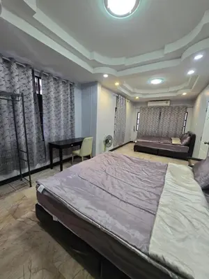a bedroom with a large bed and a table at Diamond Home in Phuket in Ban Rangeng