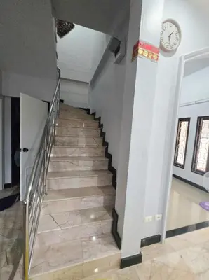 a hallway with a staircase with a clock on the wall at Diamond Home in Phuket in Ban Rangeng