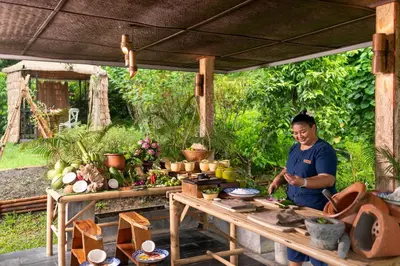 a man standing under a table with food on it at Keemala in Kamala Beach