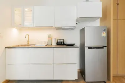a kitchen with white cabinets and a refrigerator at Large condo Surin-Bangtao Beach in Surin Beach