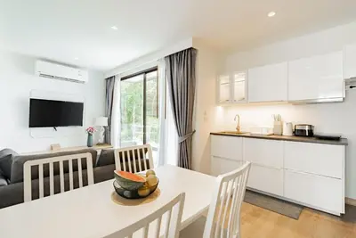 a kitchen and living room with a table and chairs at Large condo Surin-Bangtao Beach in Surin Beach