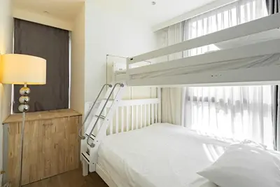 a bedroom with a bunk bed next to a window at Large condo Surin-Bangtao Beach in Surin Beach