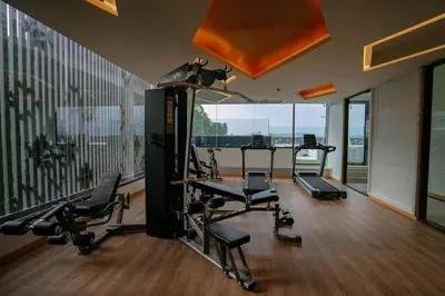 a gym with several tread machines and a large window at Large condo Surin-Bangtao Beach in Surin Beach