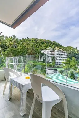 a balcony with a table and chairs and a view at Large condo Surin-Bangtao Beach in Surin Beach