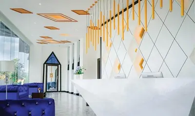 a lobby with a white table and purple chairs at Studio surin-bangtao beach in Surin Beach