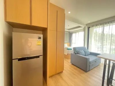 a kitchen with a refrigerator and a couch in a room at Studio surin-bangtao beach in Surin Beach