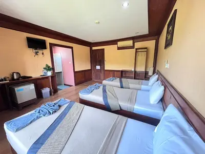 a hotel room with three beds and a flat screen tv at Phi Phi Treetop in Phi Phi Don
