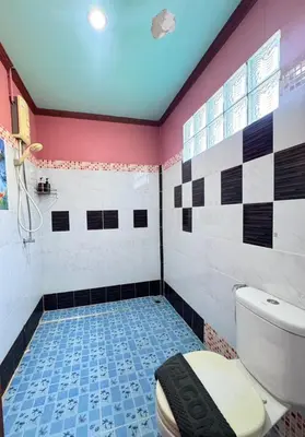 a bathroom with a toilet and a tiled floor at Phi Phi Treetop in Phi Phi Don