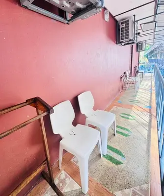 two white tables and chairs against a pink wall at Phi Phi Treetop in Phi Phi Don