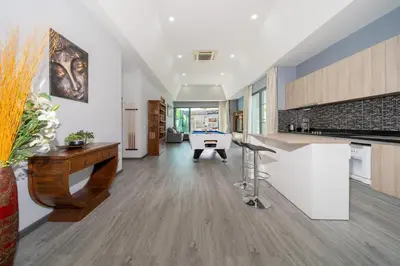a large kitchen with a desk and a table at Vanille Villa in Balinese style with swimming pool in Ban Saiyuan (1)