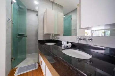 a bathroom with two sinks and a glass shower at Vanille Villa in Balinese style with swimming pool in Ban Saiyuan (1)
