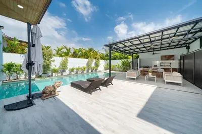 an outdoor patio with a swimming pool and a house at Vanille Villa in Balinese style with swimming pool in Ban Saiyuan (1)