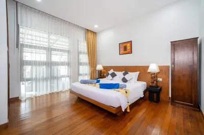 a bedroom with a bed and a large window at Vanille Villa in Balinese style with swimming pool in Ban Saiyuan (1)