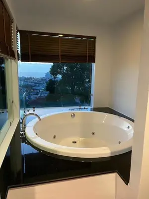 a large white bath tub in a room with a window at Thebirdhouse Patong Phuket203 in Patong Beach