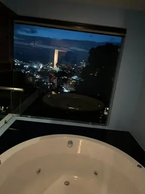 a bath tub in front of a window with a view at Thebirdhouse Patong Phuket203 in Patong Beach