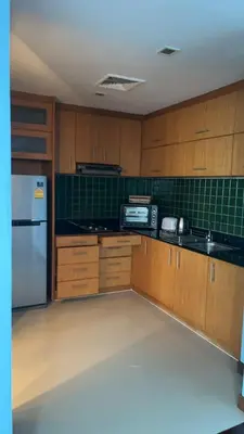 a kitchen with wooden cabinets and a white refrigerator at Thebirdhouse Patong Phuket203 in Patong Beach