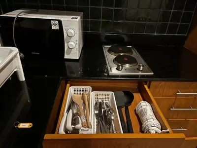 a drawer filled with kitchen utensils on a kitchen counter at Thebirdhouse Patong Phuket 202 in Patong Beach