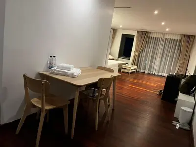 a dining room table with chairs and a living room at Thebirdhouse Patong Phuket 202 in Patong Beach