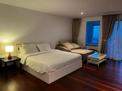 a bedroom with a large bed and a couch at Thebirdhouse Patong Phuket 202 in Patong Beach