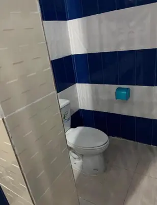 a bathroom with a toilet with a blue and white wall at Reggaein in Phi Phi Don